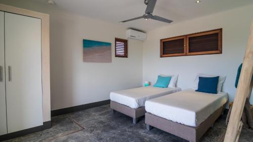 a bedroom with two beds and a window at BEACHES Bonaire in Kralendijk