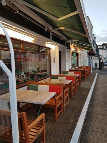 uma fila de mesas e cadeiras num pátio de restaurante em Bon Viveur Guest House em Saint Aubin