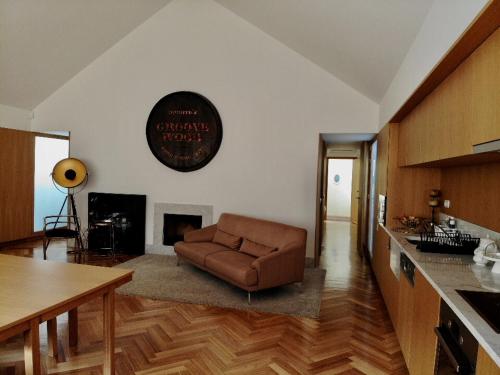 a living room with a brown couch in a kitchen at Groove-Wood Loft in Vila Nova de Gaia
