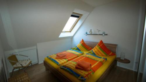 バンシンにあるHaus Auguste Appartement 20のベッドルーム1室(カラフルな毛布と枕付きのベッド1台付)