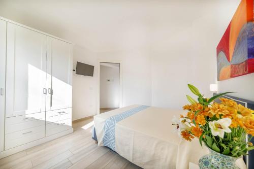 a bedroom with a bed and a vase with flowers at Ville D'Ogliastra in Cardedu
