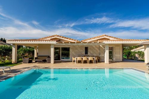 a villa with a swimming pool in front of a house at Ville D'Ogliastra in Cardedu