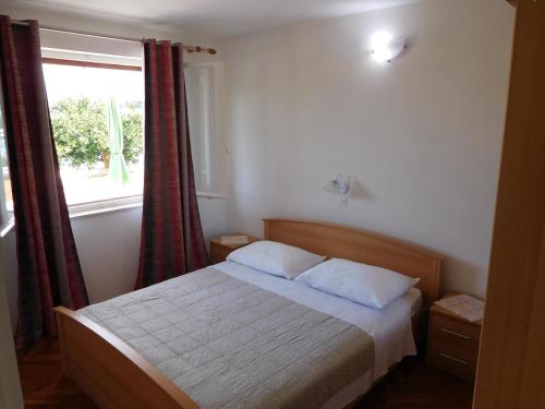 een bed in een kamer met een raam en een bed sidx sidx sidx bij Apartment Vjera in Korčula