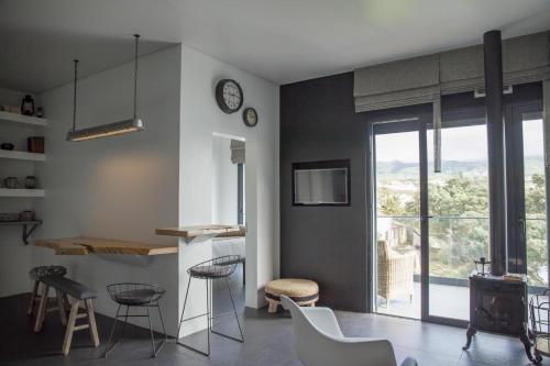 een woonkamer met een tafel, stoelen en een klok bij Graviana - Pedra Negra Charming House in Lagoa