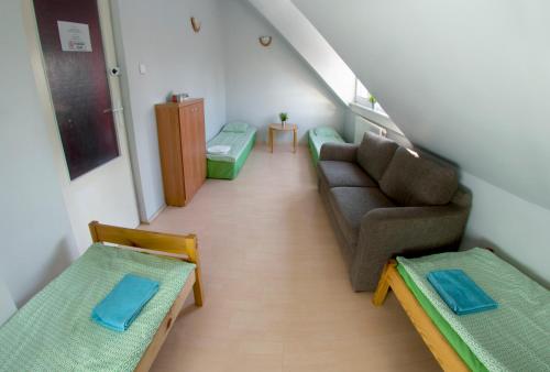 a living room with a couch and a chair at Wilanowska Hostel in Warsaw