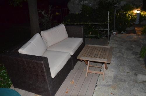 a wicker couch and a coffee table on a deck at Il Torrione in Castiglione del Lago
