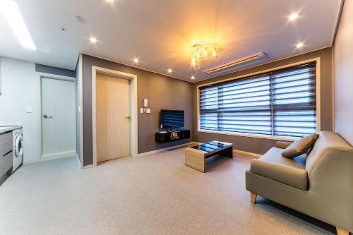 a living room with a couch and a tv at It's W in Suwon