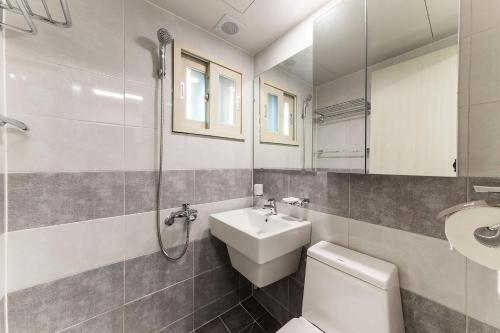 a bathroom with a sink and a toilet and a mirror at It's W in Suwon