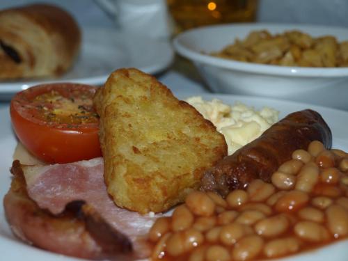 a plate of breakfast food with beans bacon beans and tomatoes at YHA Snowdon Llanberis in Llanberis