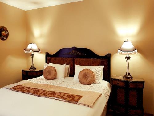 Un dormitorio con una cama con dos lámparas sobre dos mesas. en Kimberley Manor Guesthouse, en Kimberley