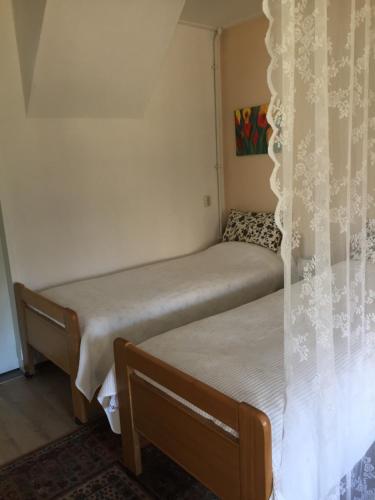 2 camas individuales en una habitación con cortinas en B&B Loon, en Loon