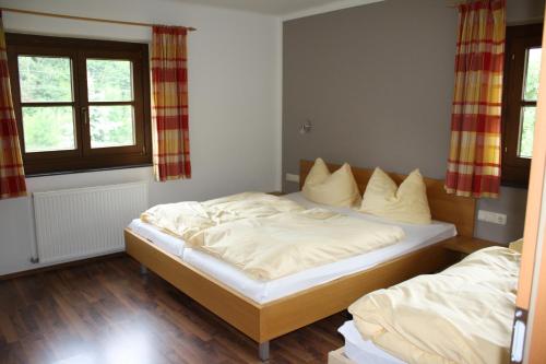 1 dormitorio con 2 camas y 2 ventanas en Appartementhaus Bergblick, en Leogang
