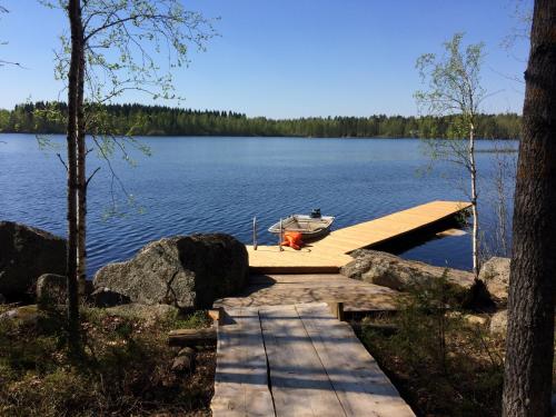 a dock with a boat on top of a lake at Hyvölän Mökit in Ähtäri