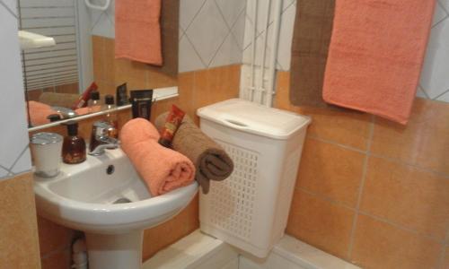 a bathroom with a sink and a toilet with towels at COQUET F2 CLIMATISE AVEC PISCINE AU LAMENTIN in Le Lamentin