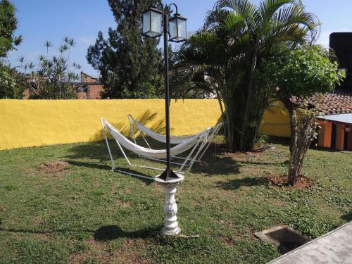 a hammock on a pole next to a yellow wall at Isla Francia in Asuncion