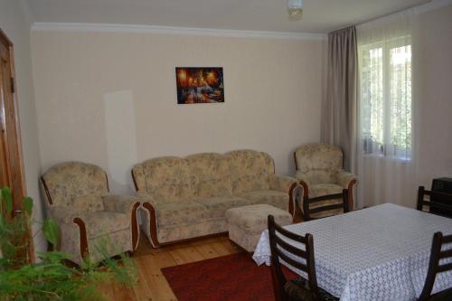 a living room with a couch and two chairs and a table at Ekaterine Guest House in Stepantsminda