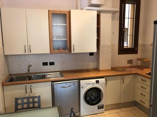 een keuken met een wasmachine en een wastafel bij Pizzardi39 - The Place Apartments in Bologna