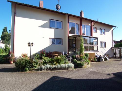 a white house with some plants in front of it at Gästehaus Casa Cristina in Bad Krozingen