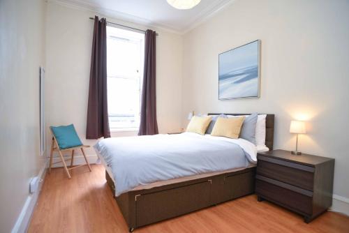 Un dormitorio con una cama grande y una ventana en Modern Flat in Rosemount/City Centre, en Aberdeen