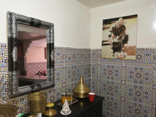 ein Badezimmer mit einem Spiegel an einer gefliesten Wand in der Unterkunft Ryad Nayla in Marrakesch