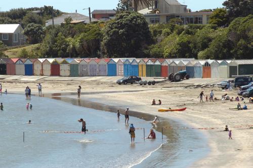 a group of people standing in the water on a beach at AAA Mana Motel in Porirua