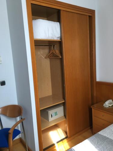 Habitación con armario, cama y escritorio. en Encasa Hotel Almansa, en Almansa
