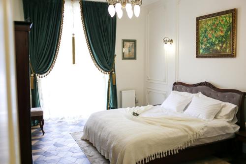 リヴィウにあるDel Rey Luxuryのベッドルーム1室(緑のカーテン付きの大型ベッド1台付)