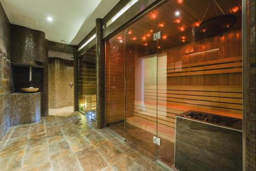 W łazience znajduje się prysznic ze szklanymi drzwiami. w obiekcie Dziki Potok Konferencje & SPA w mieście Karpacz