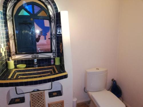 a bathroom with a sink and a toilet with a mirror at Maison Mirage B&B in Hassilabied