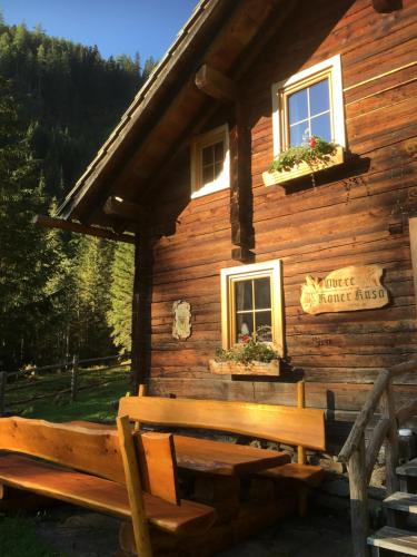 a wooden cabin with a bench in front of it at Obere Roner Kasa in Mörtschach