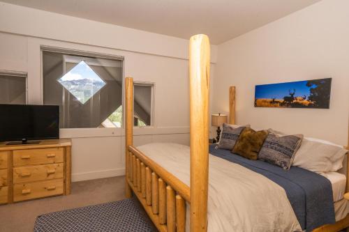 ein Schlafzimmer mit einem Etagenbett und einem Flachbild-TV in der Unterkunft Saddle Ridge I2 in Big Sky