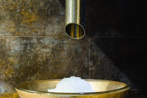 a bowl filled with white powder next to a shower at Hotel Dziki Potok Karpacz Konferencje & SPA in Karpacz