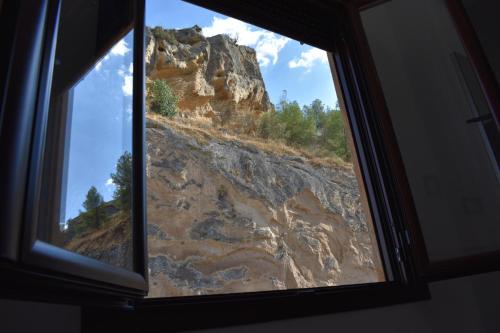 a window with a view of a rocky mountain at Iznájar Suites in Iznájar