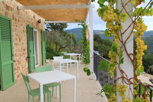 a row of tables and chairs on a balcony with grapes at Pekko in Spello