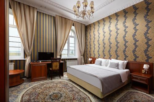 a bedroom with a bed and a desk and a television at Nikitin Hotel in Nizhny Novgorod