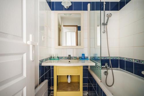 Un baño con lavabo, bañera y espejo. en Residence Port du Crouesty Cap Ocean - maeva Home, en Arzon
