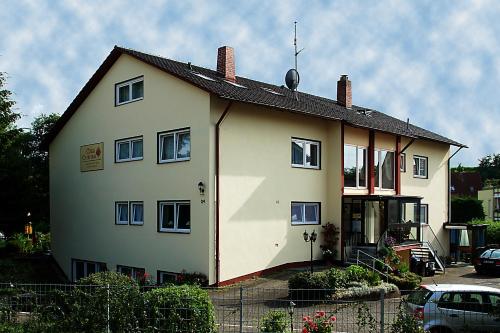 a white house with a car parked in front of it at Gästehaus Casa Cristina in Bad Krozingen
