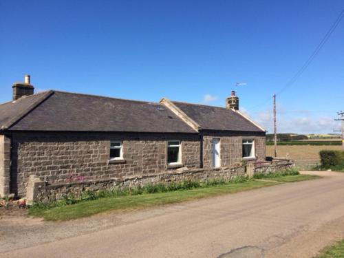 an old brick house on the side of a road at Wagtail Cottage in Berwick-Upon-Tweed