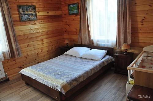 スーズダリにあるГостевой дом Пинаихаの木製の部屋にベッド1台が備わるベッドルーム1室があります。