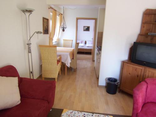 a living room with a table and a couch and a television at Gästehaus Casa Cristina in Bad Krozingen
