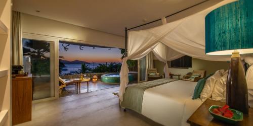 a bedroom with a bed and a view of the ocean at Vila deste Hotel in Búzios