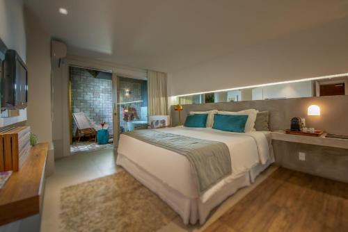 a large bedroom with a large bed and a window at Vila deste Hotel in Búzios