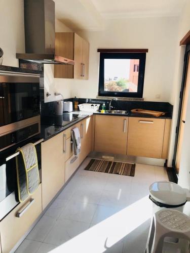 a kitchen with wooden cabinets and a window at Rother Praia da Luz Luxury Apartment in Luz
