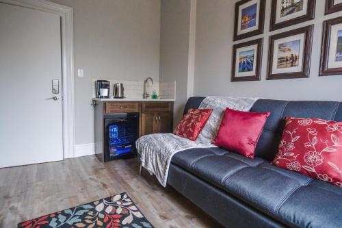 uma sala de estar com um sofá preto com almofadas vermelhas em Evanndor em Stratford