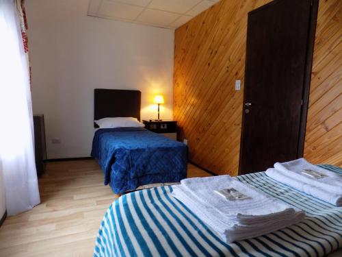 a hotel room with two beds with towels on them at Meridiano68 Apartment in Ushuaia