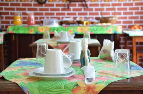 a table with plates and utensils on a table cloth at Pousada do Imperador in Paraty