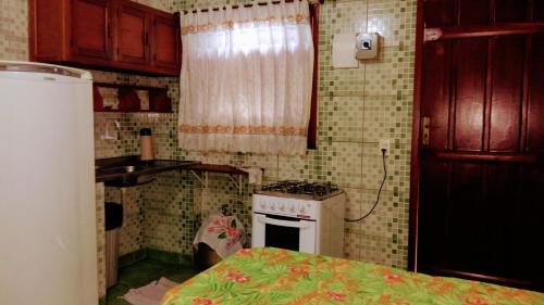 a small kitchen with a stove and a sink at Trindade Hospeda - Estúdios Vila C in Trindade