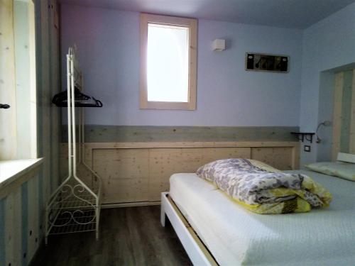 1 dormitorio con cama y ventana. en Appartamento Bosco Fontana a Predazzo en Predazzo