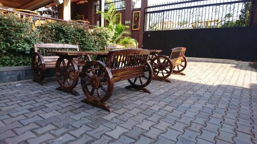 a wooden table and benches on a brick patio at The Venti Hotel & Spa in Kampala