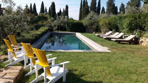 フィエーゾレにあるPalagetto di Settignanoのスイミングプールの横に座る椅子